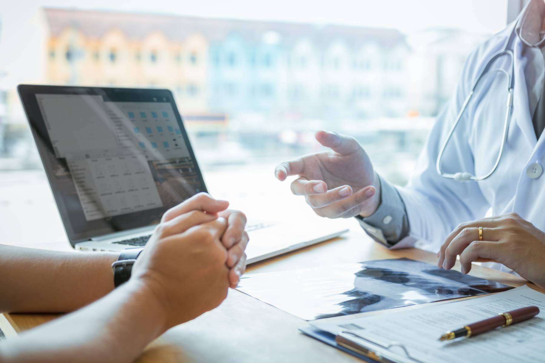 Female patient listening to doctor at desk and consulting with h Medical bill collections